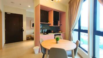 A modern kitchen with a dining area, a large window, and a door.