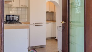 A compact kitchen with white cabinets, a stove, and a dishwasher. - Stunning private villa for 4 guests with WIFI, TV and patio (Calozzo)