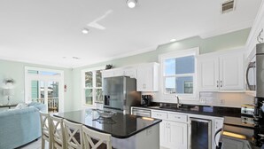 A modern kitchen with white cabinets, a central island, and stainless steel appliances.