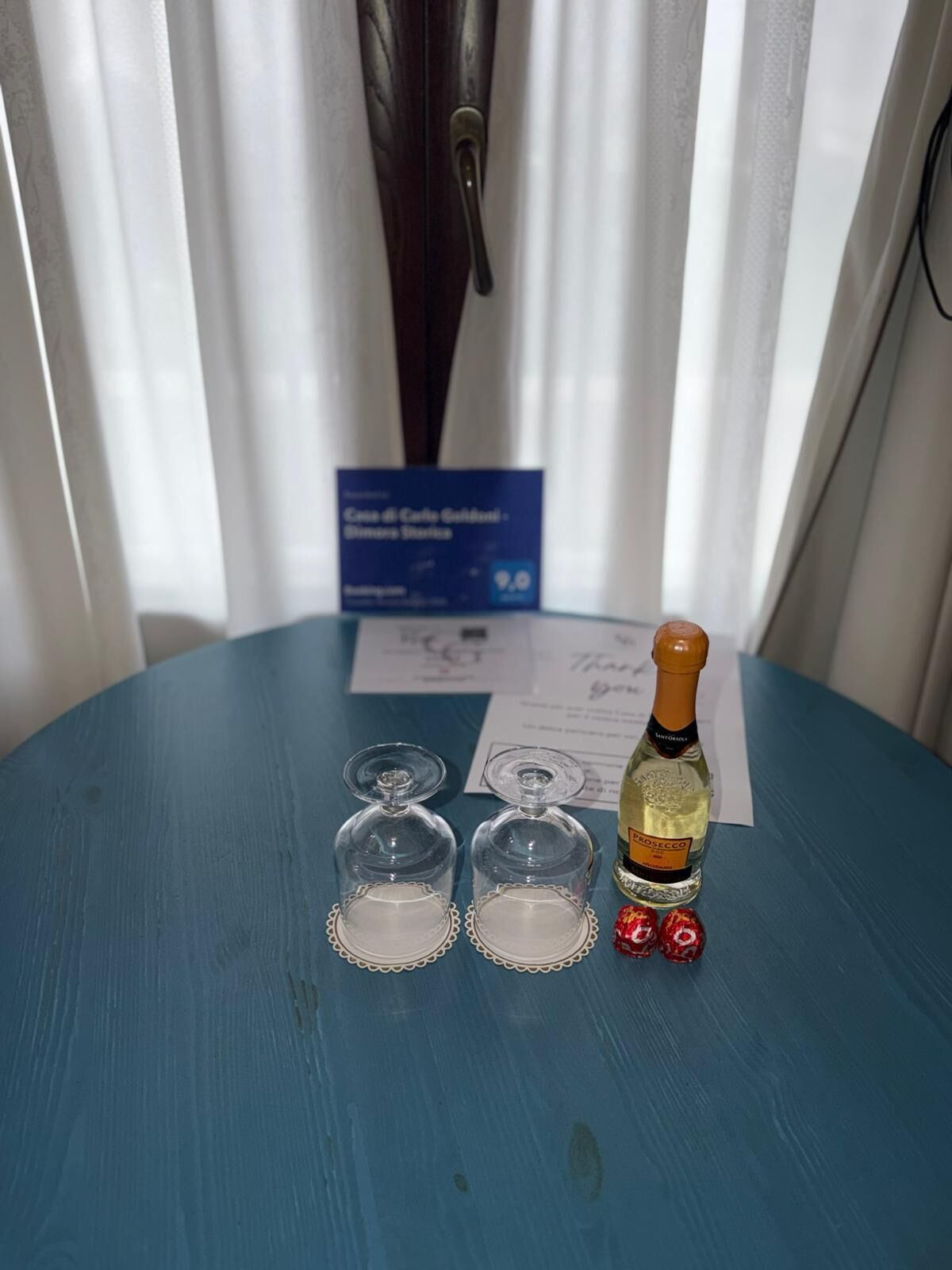 Ein Tisch mit einer Prosecco-Flasche, zwei Gläsern und zwei Lutscher.