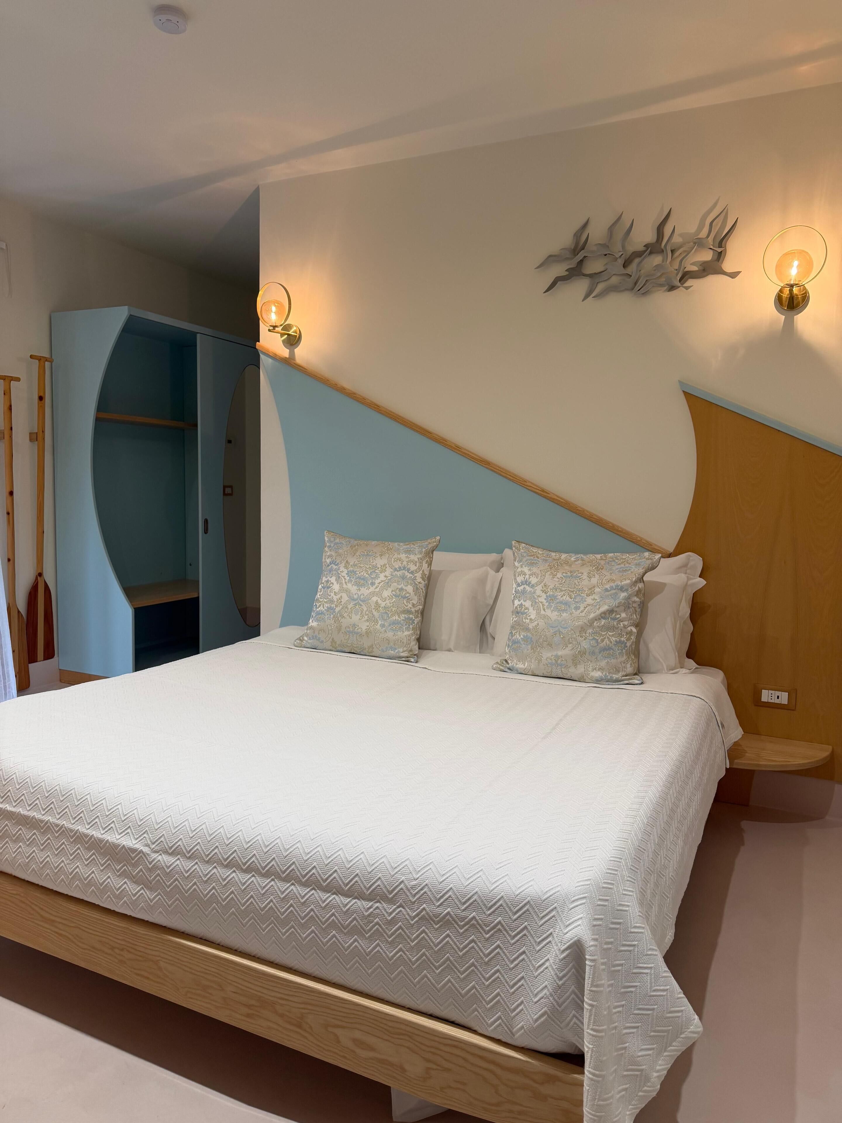 Une chambre à coucher comprenant un lit, une armoire et une étagère fixée au mur.