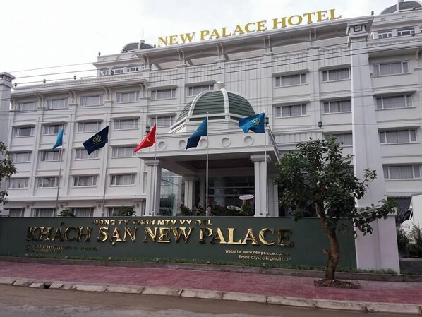 La façade du New Palace Hotel, avec le nom de l’établissement affiché en grand au-dessus de l’entrée.