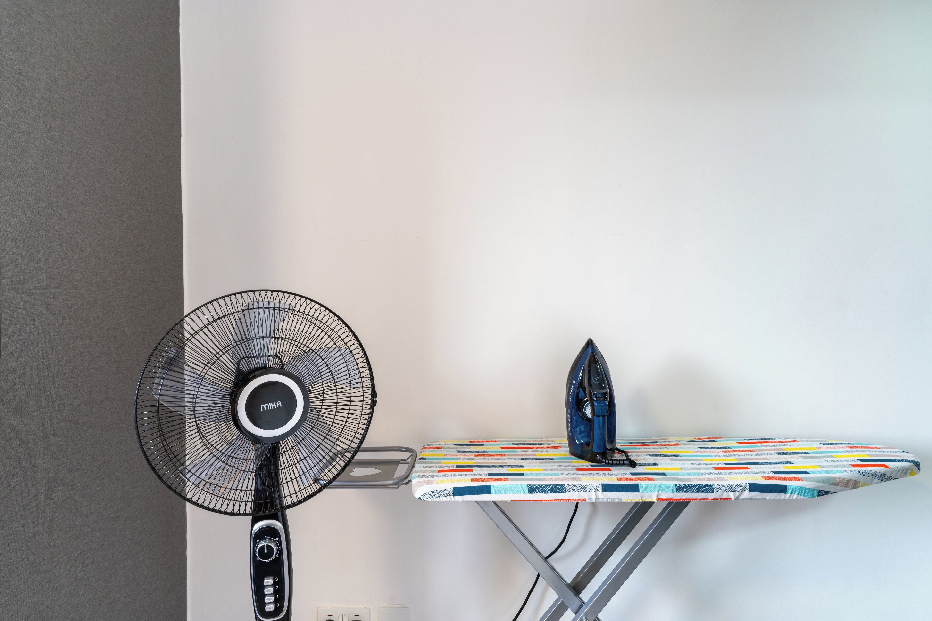 Ein Wandventilator und ein Bügelbrett mit Bügeleisen.