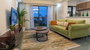 A modern living room with a green sofa, a coffee table, and a TV on a wooden console. - Skyline symmetry (Nairobi)
