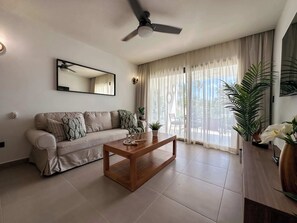 Una sala de estar moderna con un sofá, una mesa de centro y un ventilador de techo.