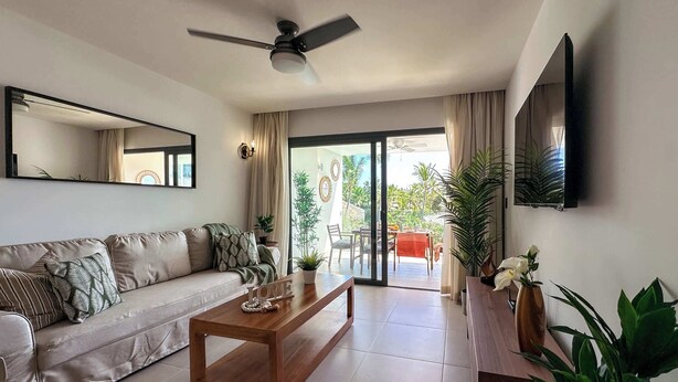 A modern living room with a sofa, coffee table, and a television mounted on the wall.
