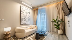 Un salon moderne avec un canapé, une table basse et un grand tableau abstrait accroché au mur.