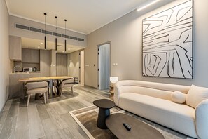 A modern living room with a sofa, a coffee table, and a dining area with chairs and a table. - Concept 7 211 in Dubai (Dubai)