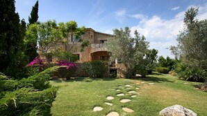 A stone building with a garden in front. - Villa Reco de Marina (Sa Pobla)