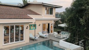 A modern house with a swimming pool, outdoor seating, and a well-maintained garden. - Amã Stays & Trails Assa 360, Goa (Anjuna)