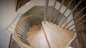 A spiral staircase with wooden steps and metal railings. - Beautiful vacation home "Nele"! Perfect for the family (Geeste)