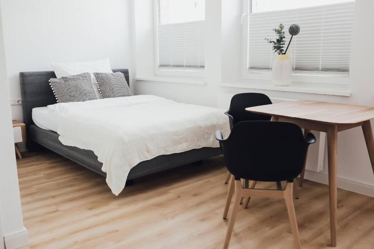 Un dormitorio con cama, escritorio y silla.