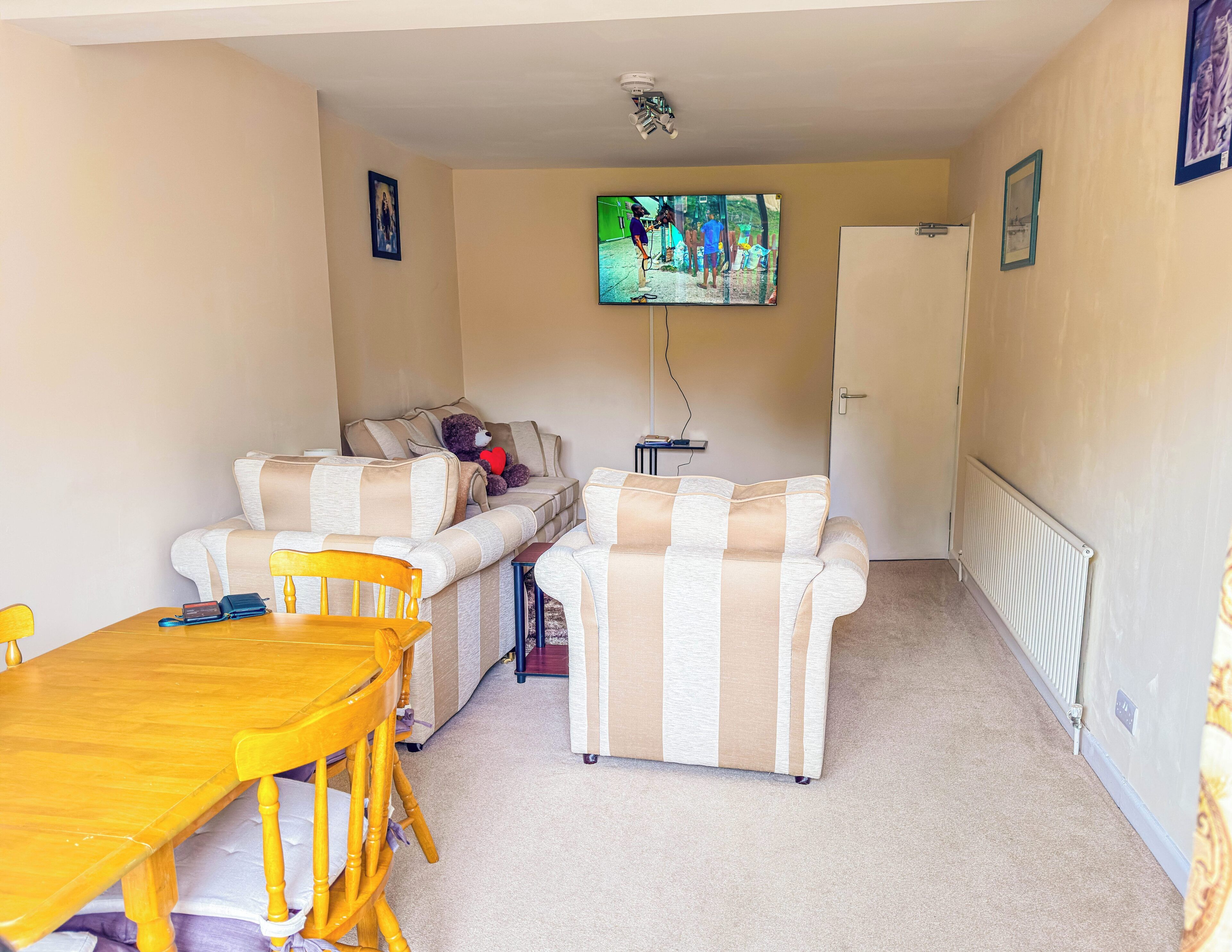 A cozy living room with a sofa, a wooden table, and a television.