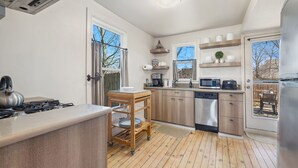 Una cocina moderna con armarios de madera, lavavajillas, microondas y cocina a gas.