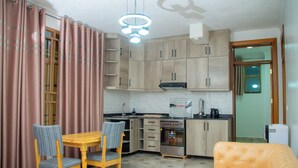 Un espacio habitable compacto con comedor, kitchenette y zona de estar.