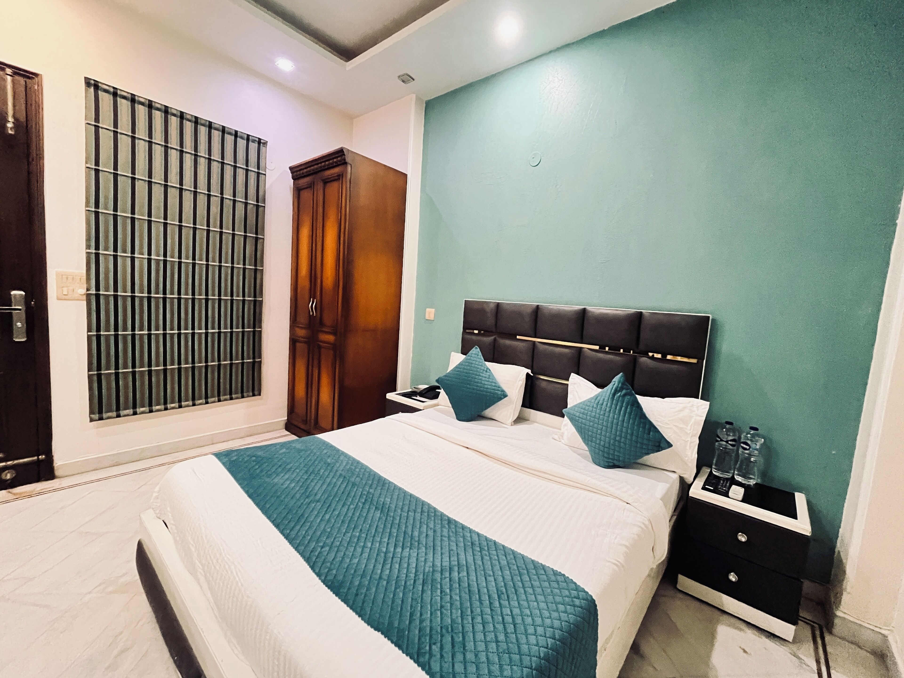 A bedroom with a bed, nightstands, a wardrobe, and a window with bars.