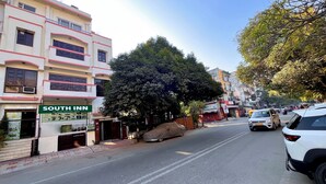 A multi-story building with a sign for 'South Inn' on the ground floor. - South Inn – Green Park South Delhi (New Delhi)