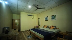 Une chambre à coucher avec un lit, des meubles en bois, un ventilateur de plafond et un appareil de climatisation.