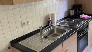 Keittiössä on kaksi pesuallasta, kahvinkeitin ja liesi.