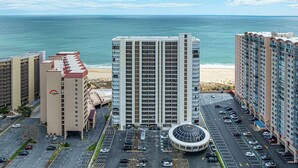 Un hôtel de grande hauteur doté d’une cour intérieure, d’un parking et offrant une vue sur l’océan.
