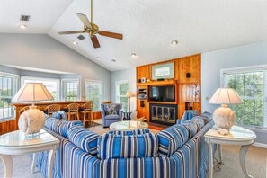 A spacious living room with a sofa, a television, and a fireplace.