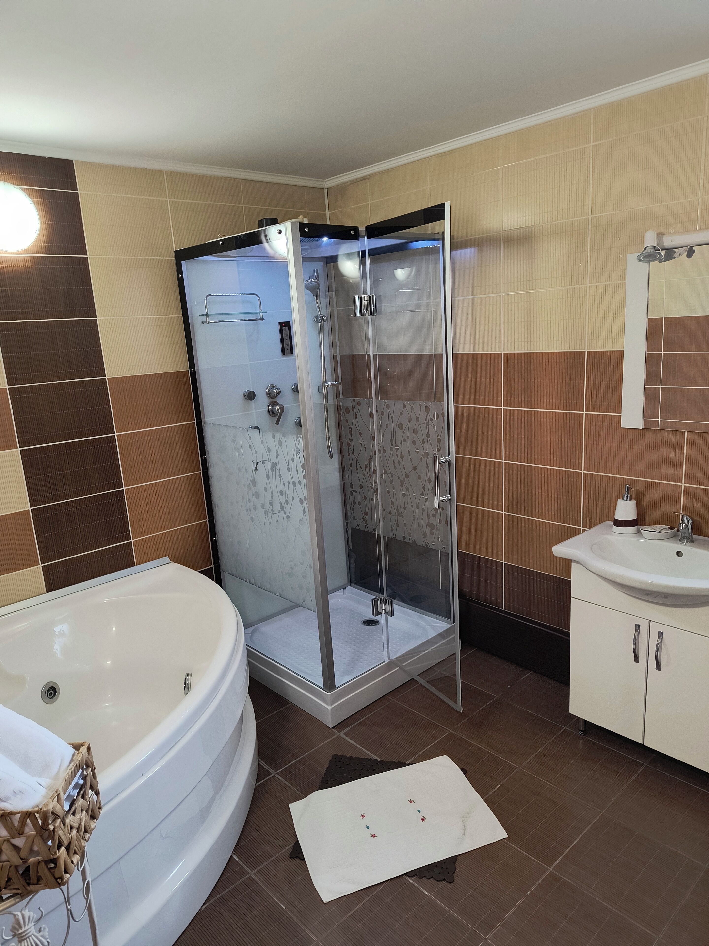 Une salle de bain dotée d’une douche à parois de verre, d’une baignoire sur pieds et d’un lavabo avec un miroir au-dessus.