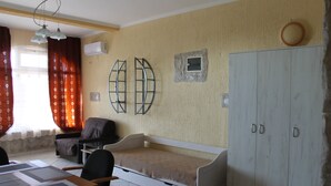 Een kamer met een bed, een kledingkast, een bureau en een stoel.