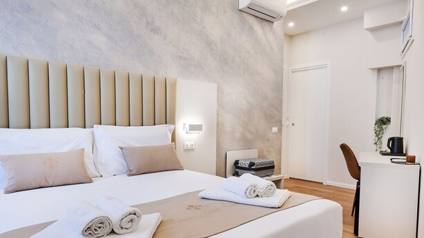 A modern hotel room with a large bed, a desk, and a chair. - florence medali rooms  (Florence)