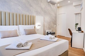 Una habitación de hotel moderna con una cama grande, un escritorio y una silla.