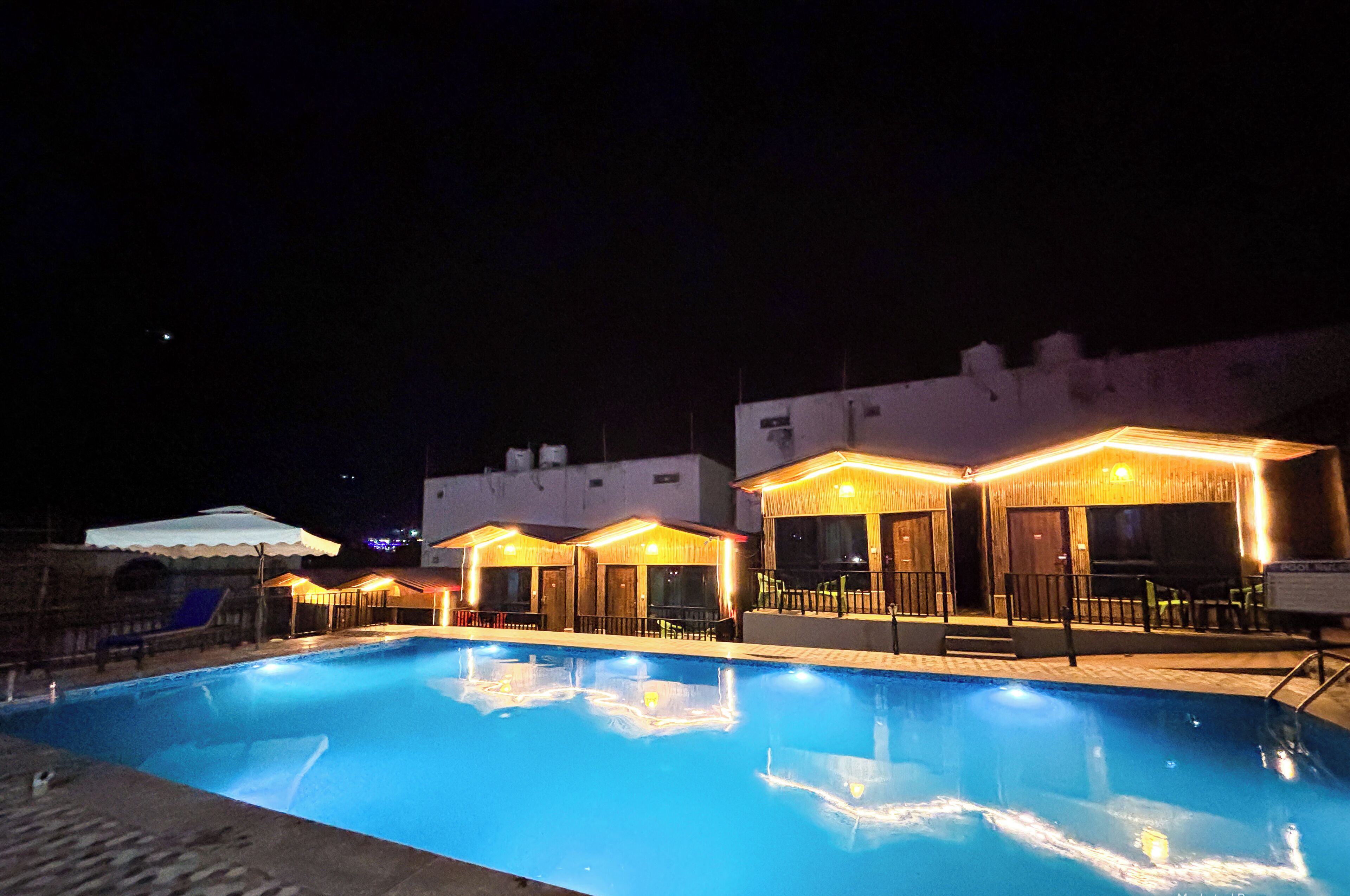Un espace piscine comprenant plusieurs coins détente et un espace de repos couvert pour le soir.