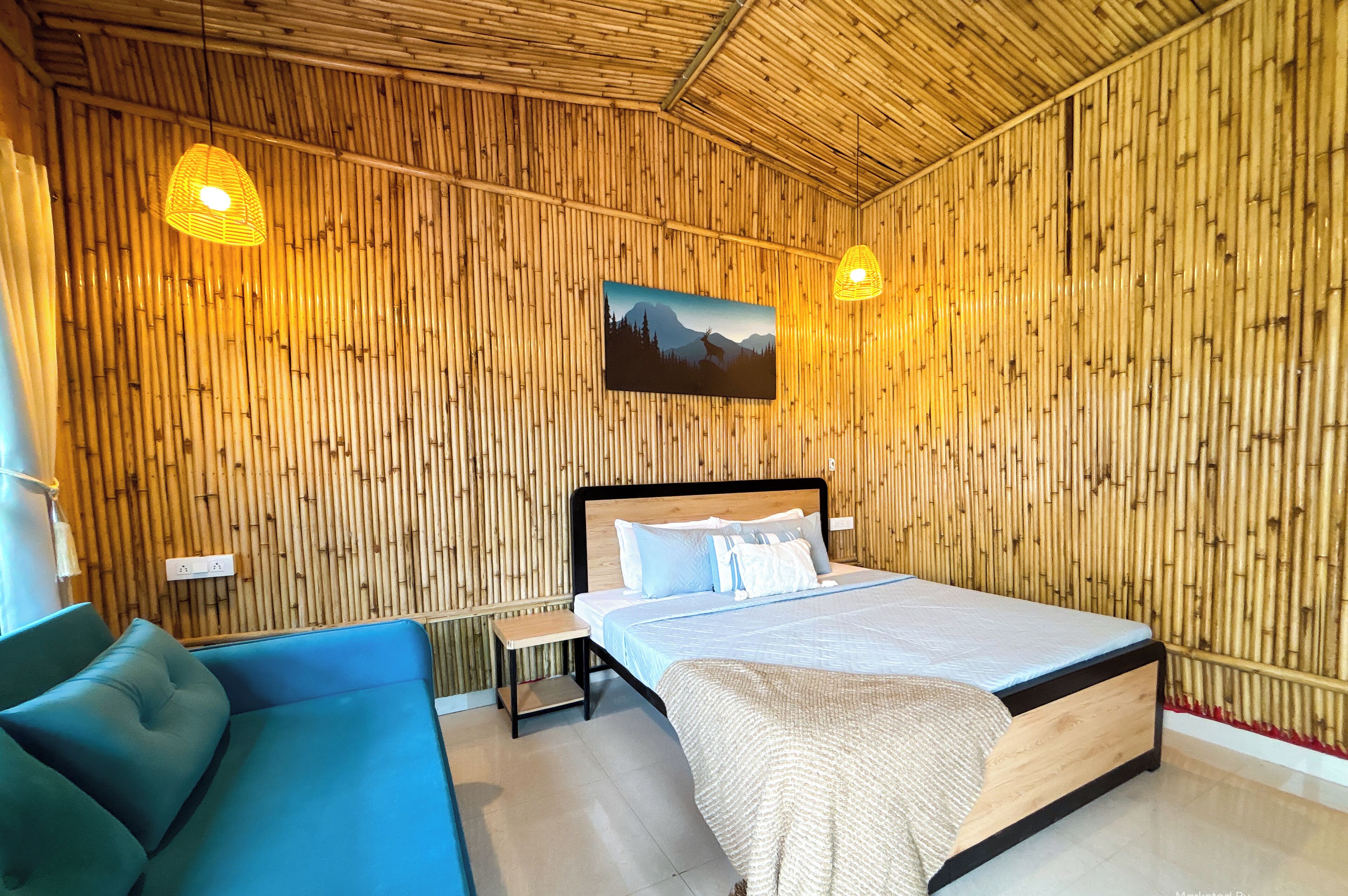 Una habitación con una cama, un sofá azul y una pared con listones de madera verticales.