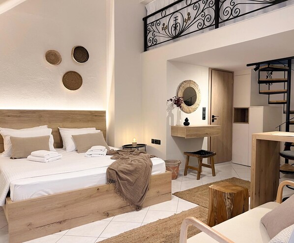 A modern hotel room with a wooden bed, a small wooden stool, a round mirror, and a wooden vanity.