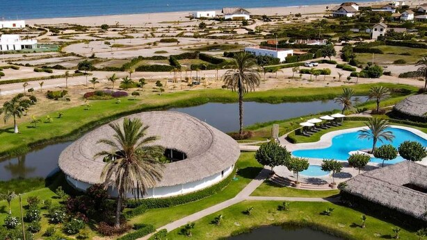 A resort with a circular building, a swimming pool, and a beach view. - Beachfront Elegance: Private Pool & Steps to Shore (Chincha Baja)