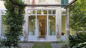 A building with a glass door entrance, a stone pathway, and potted plants.