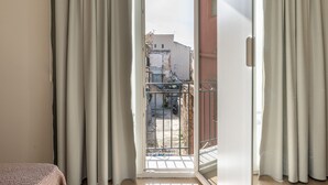 A room with a sliding glass door leading to a balcony with a metal railing. - Crispi Suite in Palermo by Wonderful Italy (Palermo)
