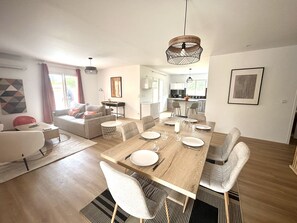 Enjoy a spacious living area with a dining table for four, comfortable seating, and a well-equipped kitchen.