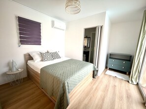 Cozy retreat with a neatly made bed, bedside table, and dresser.
