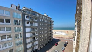 A multi-story building with balconies, a parking area, and a view of the beach. - Apartment in Knokke Near the Beach (Knokke-Heist)