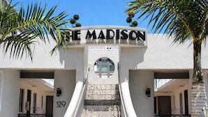 A hotel entrance with a sign reading 'THE MADISON,' a staircase, and palm trees. - Hollywood Beach 1-Min Walk | King Bed | Beach Gear (Hollywood)