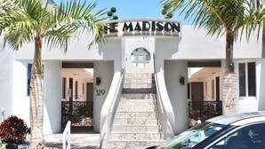 A building entrance with a sign reading "THE MADISON" and a staircase leading to the entrance.