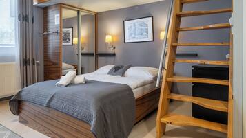 A bedroom with a wooden bed, a ladder, a mirror, and a framed picture on the wall.