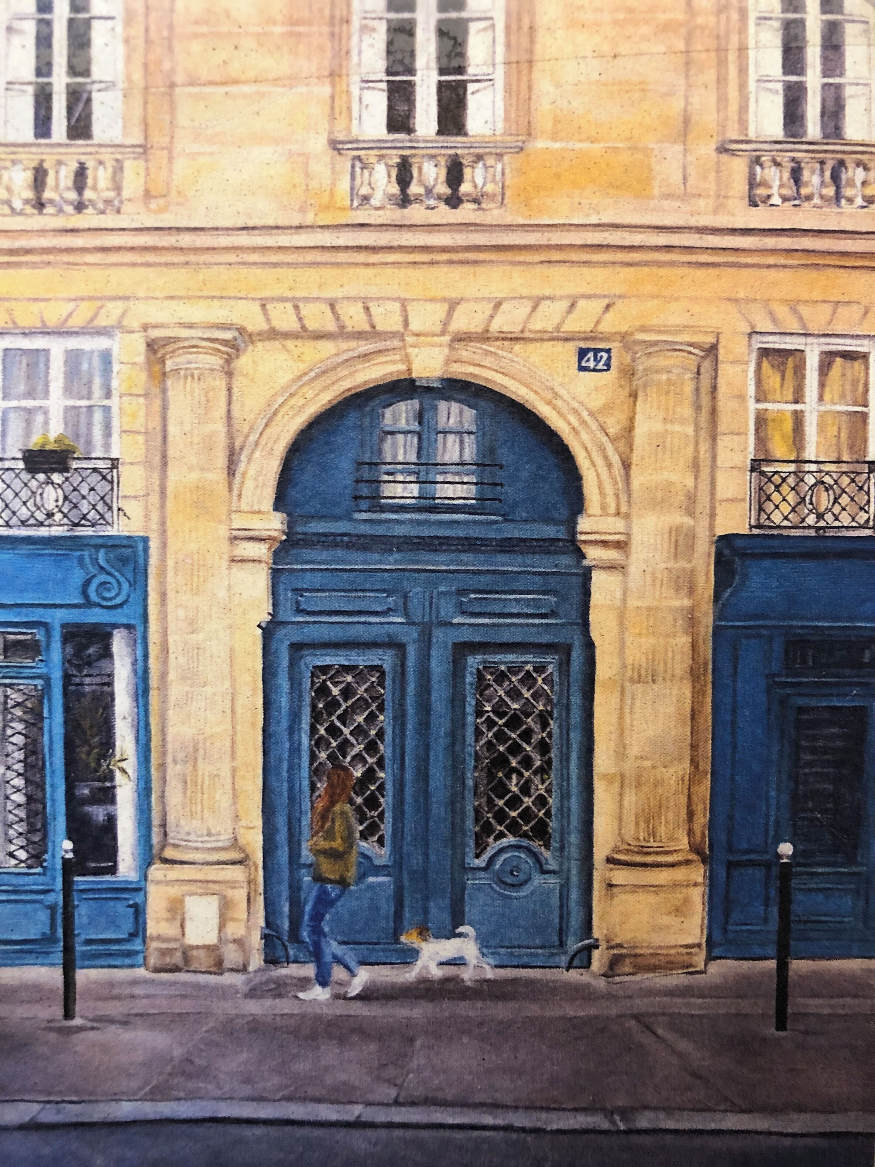 Un bâtiment avec une porte et des fenêtres bleues, une personne promenant un chien, et une enseigne portant le numéro 42 au-dessus de la porte.