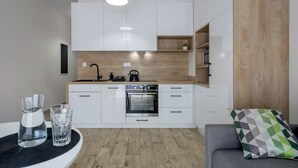 Een moderne keuken met witte kasten, een inbouwoven en een houten aanrecht.