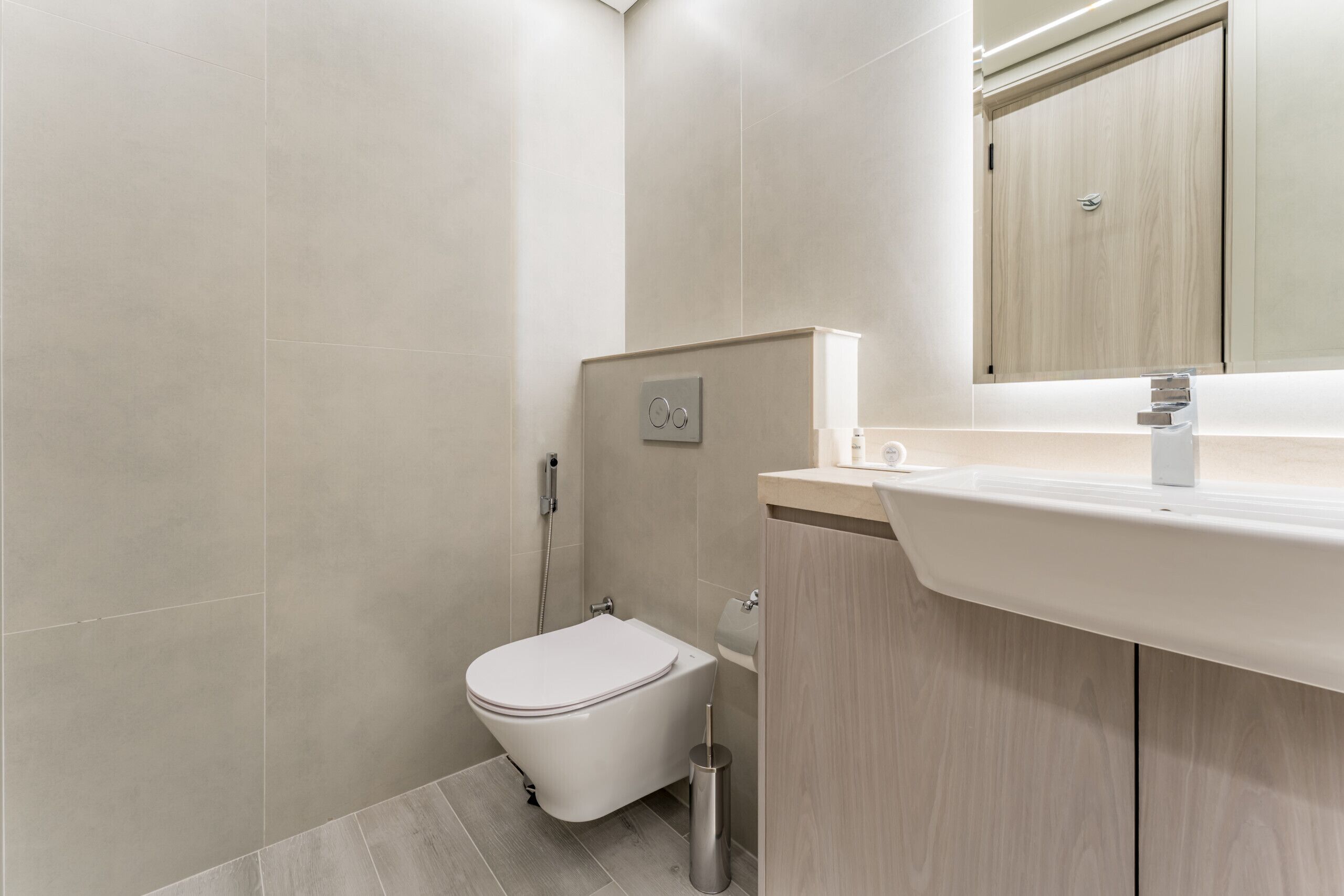 Une salle de bain moderne avec des toilettes, un lavabo et un miroir.