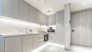 Una cocina moderna con armarios de madera, horno integrado y pileta de acero inoxidable.