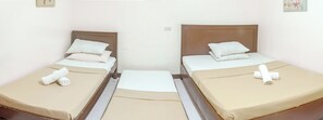 A hotel room with two single beds, each with a beige bedspread and white pillows. - Davao Hub Dormitel Bed & Breakfast (Davao)