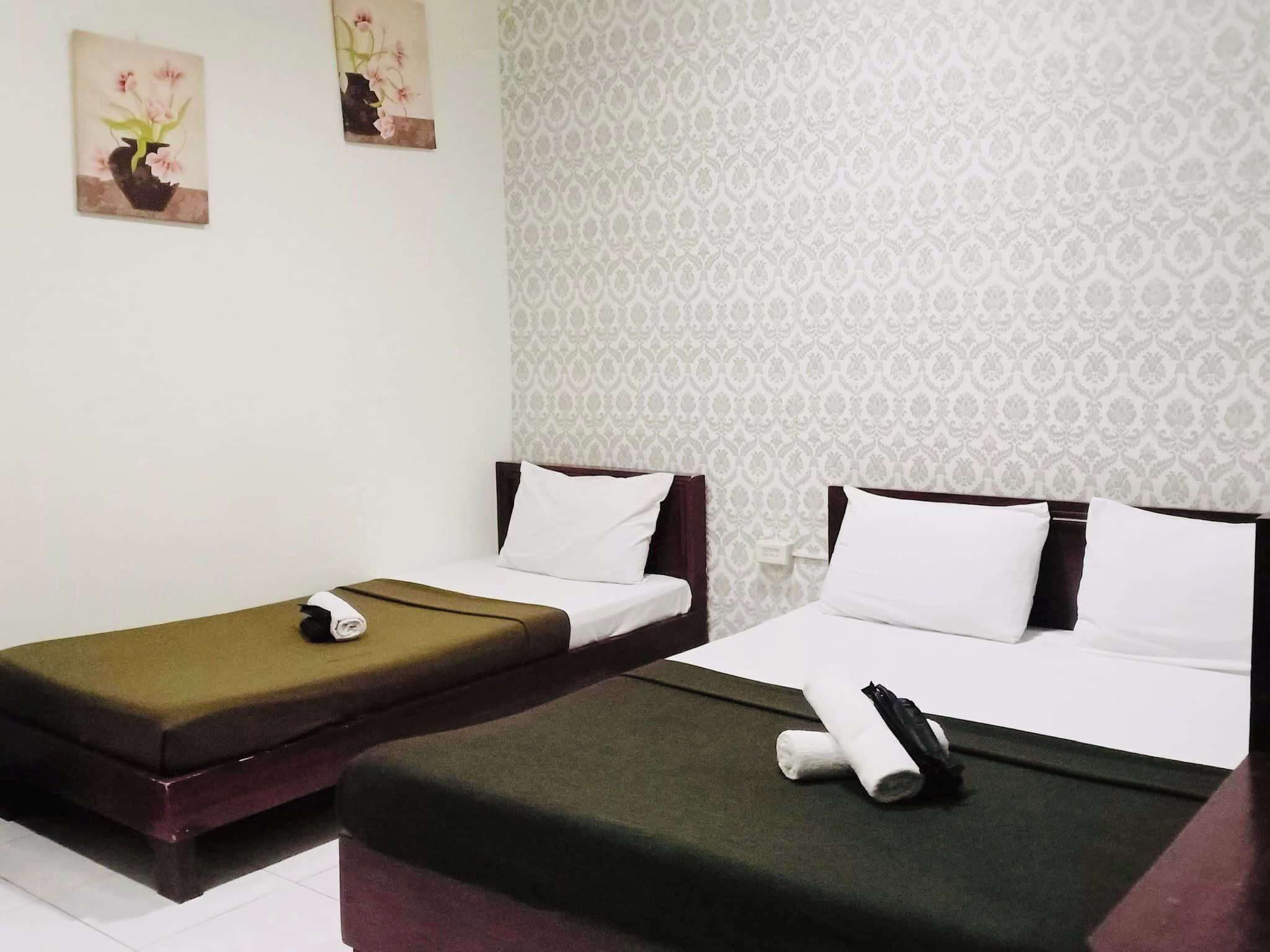 Habitación de hotel con dos camas individuales, una mesita y una obra de arte colgada en la pared.