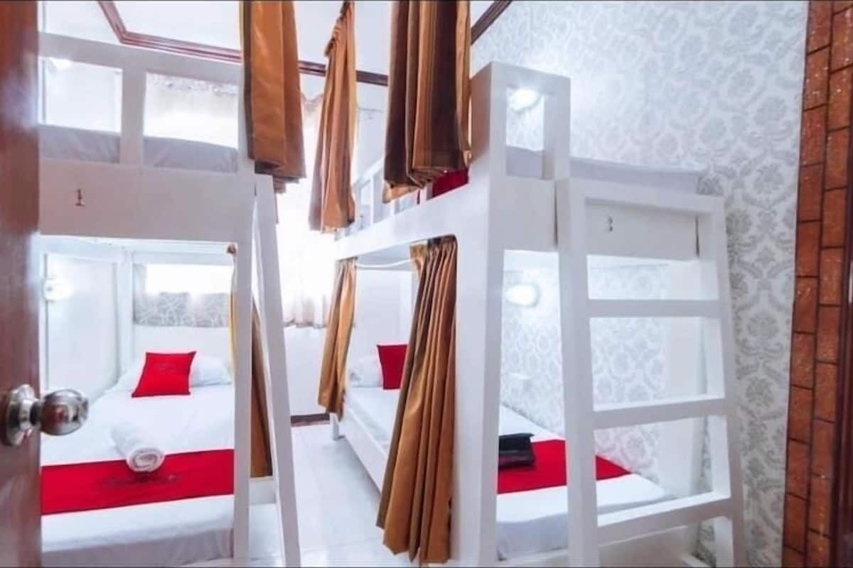 A room with bunk beds, white walls, and a wooden door.