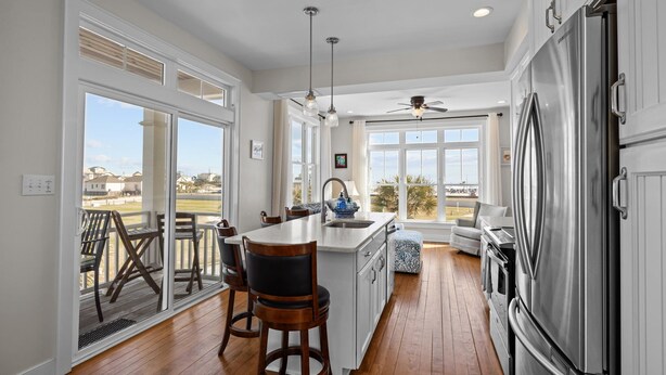 A modern kitchen with a large island, stainless steel appliances, and a view of the outdoors. - Exhibit E- Pet Friendly Townhome in Atlantic Beach (Atlantic Beach)
