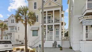 A coastal property with a balcony, a sign for 'Gulf Coast Surf Classic Surf Shop', and a 'HTR Coastal Properties' sign. - Exhibit E- Pet Friendly Townhome in Atlantic Beach (Atlantic Beach)